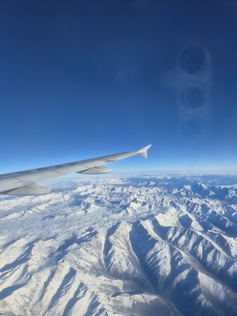 Snow-capped mountains viewed from plane window en route to Nyingchi